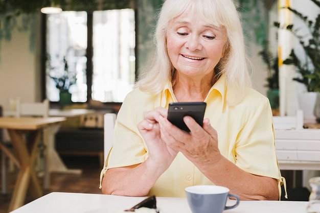 aged-woman-using-smartphone-home_23-2148216458